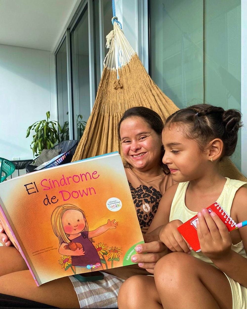 Oriana leyendo sobre síndrome de Down con una niña